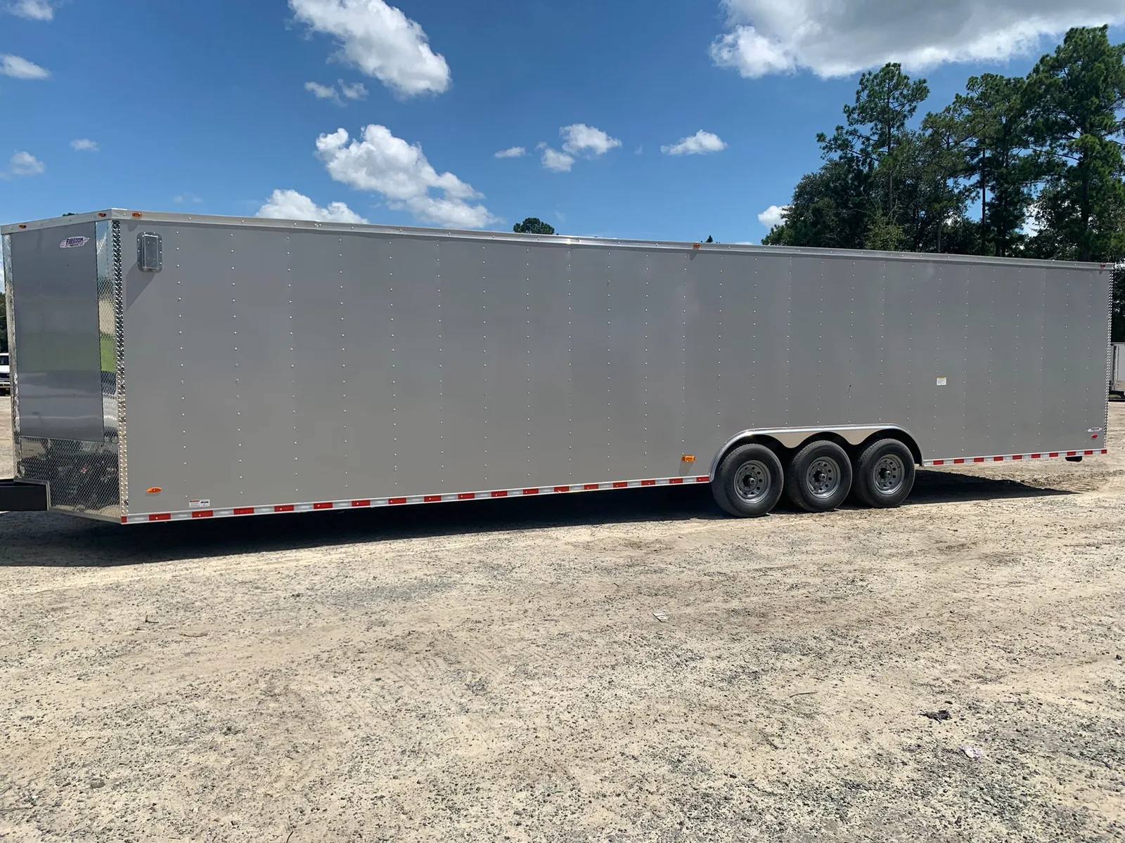 White composite 36 foot enclosed cargo trailer with V-nose and ATP nose guard