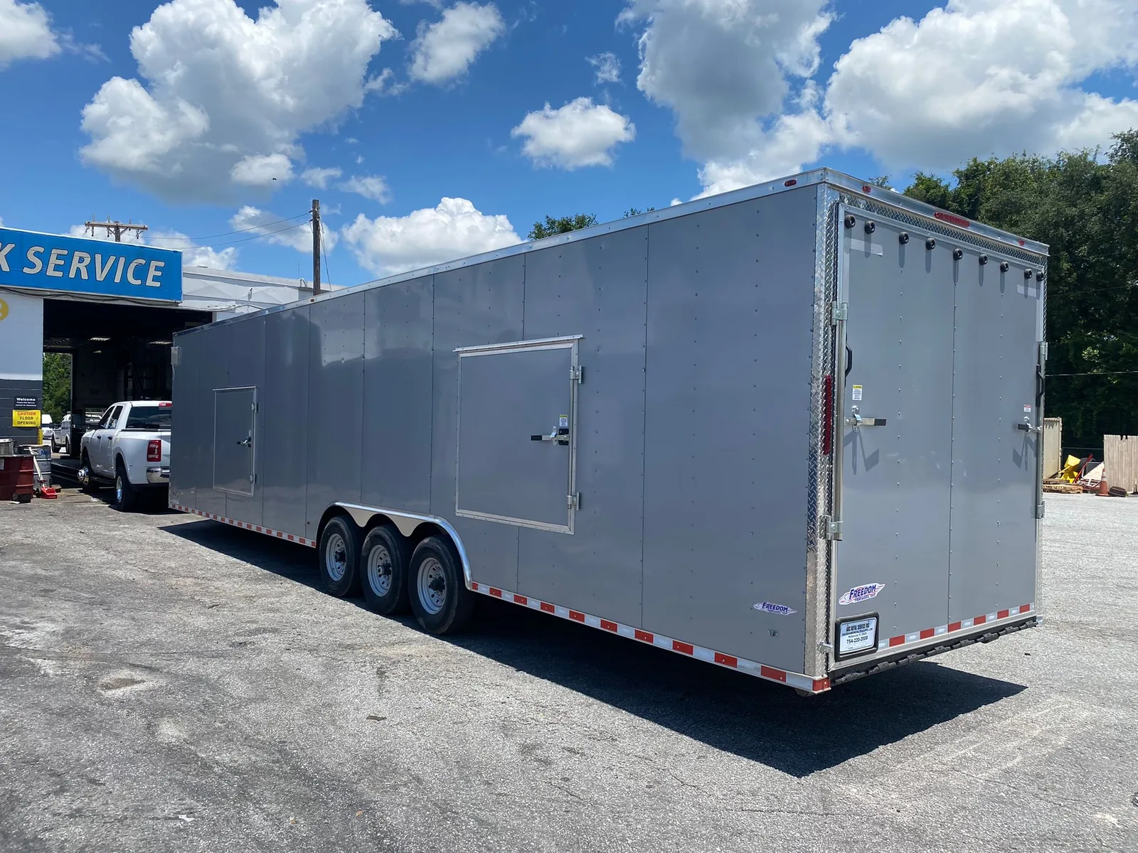 Premium 36 foot enclosed car hauler trailer with composite exterior on a paved lot