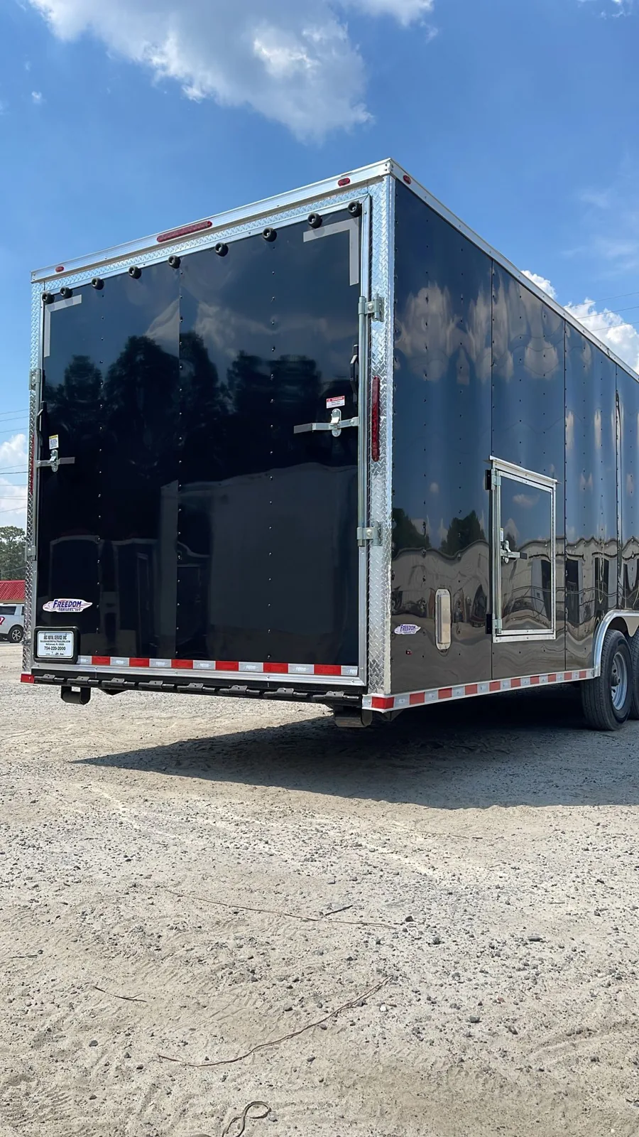 Rear view of an enclosed trailer with ramp and bogey wheels
